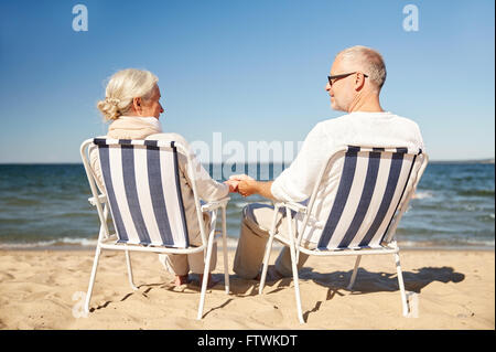 Happy senior couple dans des chaises sur la plage d'été Banque D'Images