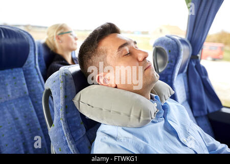 Man sleeping in billet d'autobus avec oreiller cervical Banque D'Images