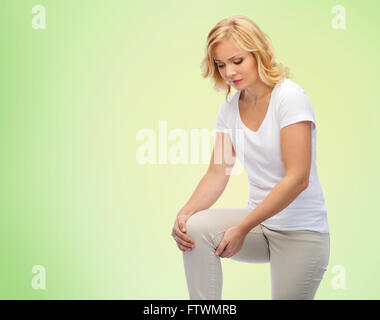 Malheureuse femme souffrant de douleur dans la jambe à la maison Banque D'Images