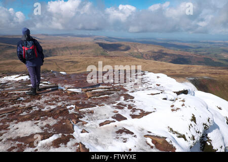 Brecon Beacons, un marcheur admire la vue en regardant vers le nord à partir de Pen Y Fan en Mars Banque D'Images