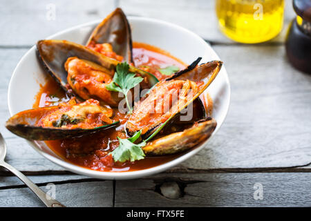 Les moules de Nouvelle-Zélande dans la tomate et sauce aux herbes Banque D'Images