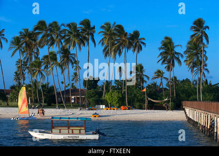 Plage de sable blanc et de la jetée pour les activités ci-dessous palmiers en face de l'Hôtel Résidence à l'Océan Indien Zanzibar Tan Banque D'Images