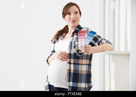 Femme enceinte le choix de couleurs pour la chambre de bébé Banque D'Images