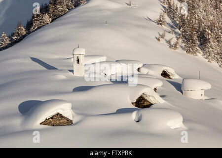 Les baraques et le clocher de l'Alpe Cima entouré par des mètres de neige Banque D'Images