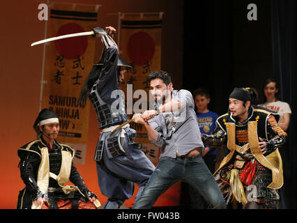 Tokyo, Japon. Mar 29, 2016. Un touriste étranger essayez d'effectuer épée bataille avec des acteurs habillés en costume de guerrier samouraï dans un théâtre à Tokyo, le mardi 29 mars, 2016 dans le cadre de la promotion du tourisme pour les visiteurs d'outre-mer. Les touristes étrangers ont participé et apprécié les arts martiaux traditionnels japonais geisha et expériences de divertissement. Le gouvernement japonais a annoncé mercredi qu'elle vise à attirer 40 millions de visiteurs étrangers au Japon en 2020 après avoir atteint l'objectif antérieur de 20 millions de 4 ans d'avance sur schdeule en 2015. © Yoshio Tsunoda/AFLO/Alamy Live News Banque D'Images