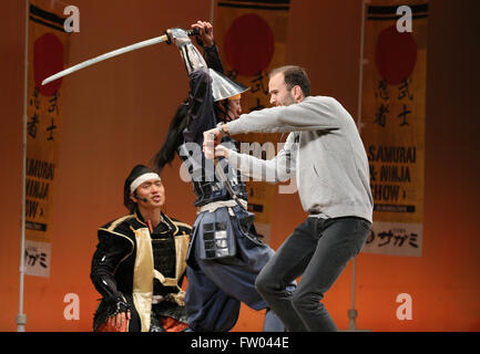 Tokyo, Japon. Mar 29, 2016. Un touriste étranger essayez d'effectuer épée bataille avec des acteurs habillés en costume de guerrier samouraï dans un théâtre à Tokyo, le mardi 29 mars, 2016 dans le cadre de la promotion du tourisme pour les visiteurs d'outre-mer. Les touristes étrangers ont participé et apprécié les arts martiaux traditionnels japonais geisha et expériences de divertissement. Le gouvernement japonais a annoncé mercredi qu'elle vise à attirer 40 millions de visiteurs étrangers au Japon en 2020 après avoir atteint l'objectif antérieur de 20 millions de 4 ans d'avance sur schdeule en 2015. © Yoshio Tsunoda/AFLO/Alamy Live News Banque D'Images