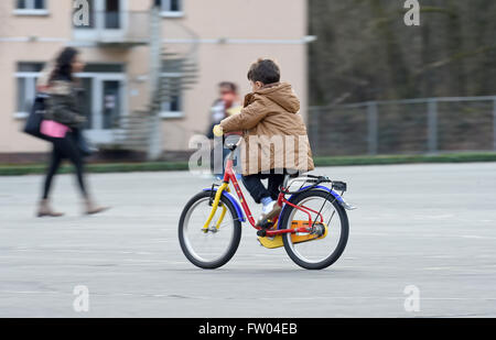 Praha,. 30Th Mar, 2016. Un enfant réfugié monte un vélo à l'emplacement du camp de réfugiés de Fallingbostel Ost d'hébergement à Bad Fallingbostel, Allemagne, 30 mars 2016. Environ 850 sont actuellement logés au Camp Ost. Photo : HOLGER HOLLEMANN/dpa/Alamy Live News Banque D'Images