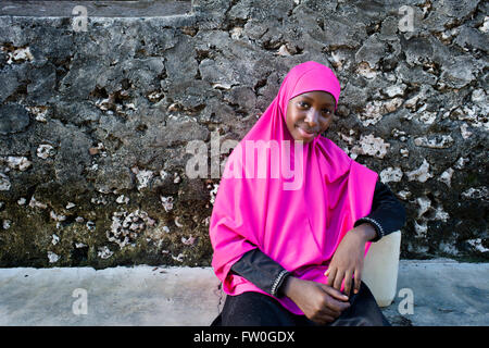 Jeune fille avec des vêtements rose à Kizimkazi Dimbani village, côte ouest, Zanzibar, Tanzanie. Banque D'Images