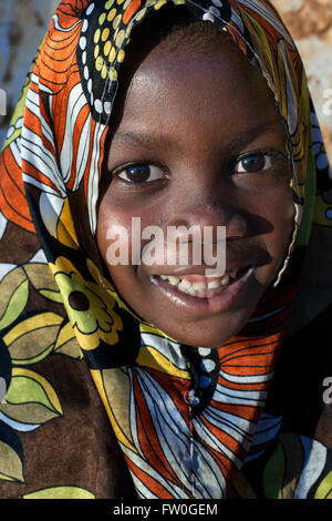 Jeune fille avec des vêtements de couleur à Kizimkazi Dimbani village, côte ouest, Zanzibar, Tanzanie. Banque D'Images