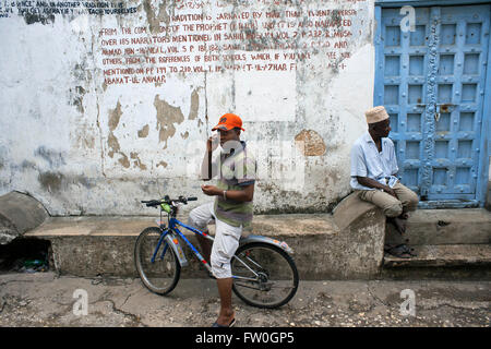 La population locale et de location dans l'une de Stone Town s labyrinthe de rues étroites, Zanzibar, Tanzanie. Banque D'Images