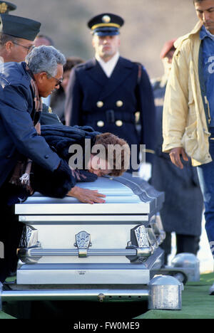 Arlington, Virginia, USA, 28 décembre 1989 La mère d'Alejandro L. Manriquelozano, Spécialiste, USA Bataillon de Rangers, se trouve plus de pleurs son cercueil lors de ses funérailles aujourd'hui au cimetière national d'Arlington. Manriquelozano spécialiste Alejandro L., 30 ans, a été enterré avec les honneurs militaires, y compris 3 salves de fusil et le jeu d'entailles, de sol couvert de neige à Arlington, à portée de vue du Capitole et le Washington Monument. Credit : Mark Reinstein Banque D'Images