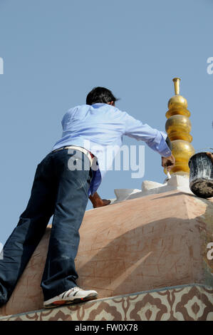 Un peintre met la touche finale à un dôme restauré au Fort Amber, Jaipur en Inde du Nord. Banque D'Images