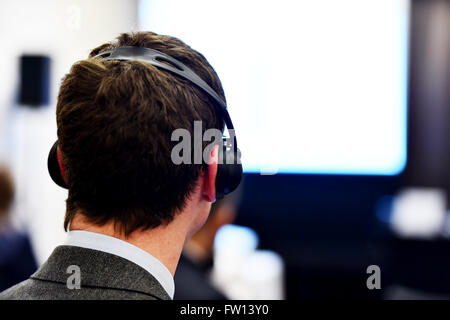 À l'aide de personnes méconnaissables dans l'oreille d'écouteurs pour la traduction pendant l'événement Banque D'Images