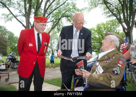 Topeka, Kansas, États-Unis, 26 mai 2014. Le sénateur républicain Pat Roberts du Kansas des entretiens avec 99 ans, vétéran de la DEUXIÈME GUERRE MONDIALE Le caporal de l'Armée de Charles Hamm qui ont servi dans la 101st Airborne Division savent que les Screaming Eagles. Ici il est montrant au sénateur Roberts une photo de lui-même et le général Dwight Eisenhower. Dans le manteau rouge à gauche est ancien Marine Le Caporal Jim Freel, qui a servi avec la 5e Division de marines et fut blessé à l'atterrissage sur Iwo Jima. Freel est également l'ancien chef de la Police de Topeka. Credit : Mark Reinstein Banque D'Images