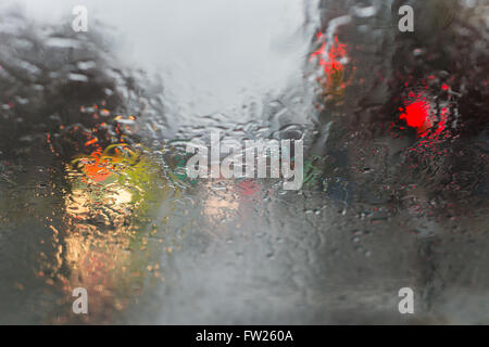 Photo floue de trafic à travers un pare-brise de voiture lors de fortes pluies. Banque D'Images