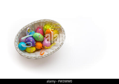 Collection d'oeufs de Pâques dans le panier blanc isolé sur fond blanc Banque D'Images