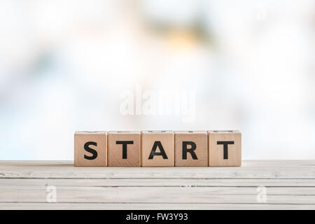 Commencer signe fait de dés sur une table en bois Banque D'Images