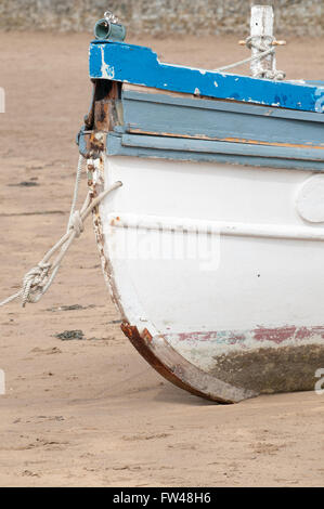 Un vieux bateau de pêche amarrés sur la plage à marée basse Banque D'Images