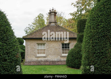 L'ancienne porte house à l'arbre d'if topiaire avenue au Clipsham, Lincolnshire. Banque D'Images