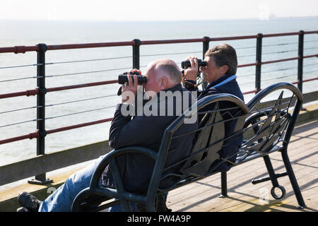 Vieux couple regardant la mer si jumelles, Jetée de Southend, Southend-on-Sea, Essex, UK Banque D'Images