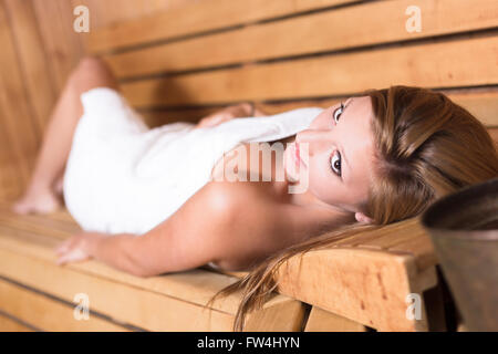 Dame de vous détendre dans un sauna traditionnel en bois. Banque D'Images