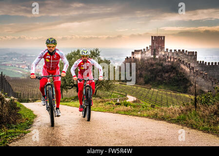 Soave, Italie - 27 mars 2016 : Les cyclistes train après une tempête sur les collines entourant le château de Soave. Banque D'Images