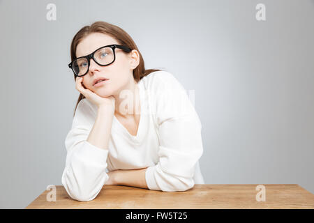 Ennuyer triste adolescente dans les verres de l'emplacement de la table plus de Gray Banque D'Images