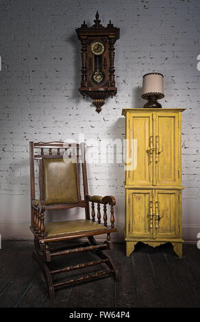 Composition du fauteuil à bascule en bois rétro jaune, placard et horloge à pendule dans la salle de séjour Banque D'Images