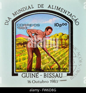 Guinée-Bissau - circa 1983 : timbre imprimé dans la République de Guinée-Bissau la commémoration de la journée mondiale de l'alimentation, montrant un agriculteur Banque D'Images