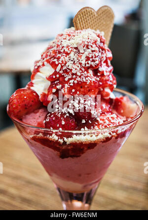 Icecream dessert avec fraises et crème fouettée servi dans une tasse en verre Banque D'Images