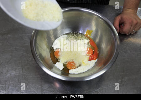 Ajouter les œufs en chef de fromages pour faire une omelette, Gubbio, Ombrie, Italie Banque D'Images