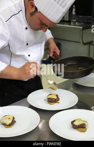 Un chef cuisinier prépare des plats de viande dans sa cuisine,Gubbio Ombrie,Italie, Banque D'Images
