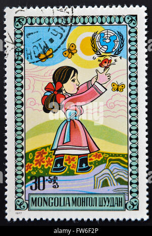 Mongolie - circa 1977 : timbres en Mongolie montre Girl chasing butterflies, vers 1977 Banque D'Images