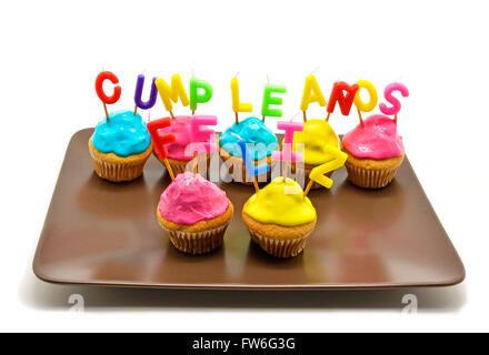 Cupcakes d'anniversaire avec des bougies joyeux anniversaire en espagnol Banque D'Images