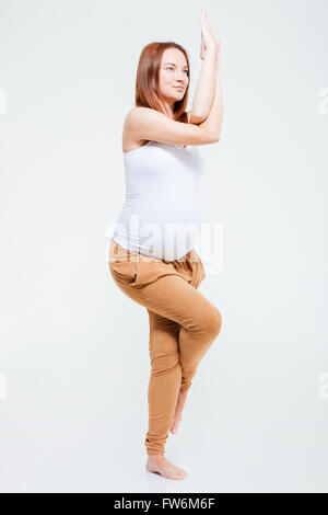 Portrait of a pregnant woman doing stretching exercice isolé sur fond blanc Banque D'Images