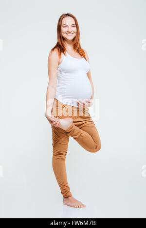 Portrait of a pregnant woman doing stretching exercice isolé sur fond blanc Banque D'Images