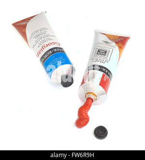 Deux tubes de peinture rouge et bleu sur fond blanc dentelle Banque D'Images