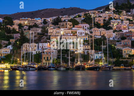 Maisons traditionnelles et des navires au port de Symi, Grèce la nuit Banque D'Images