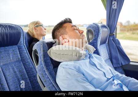 Man sleeping in billet d'autobus avec oreiller cervical Banque D'Images