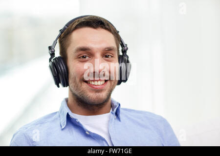 Smiling young man in headphones at home Banque D'Images