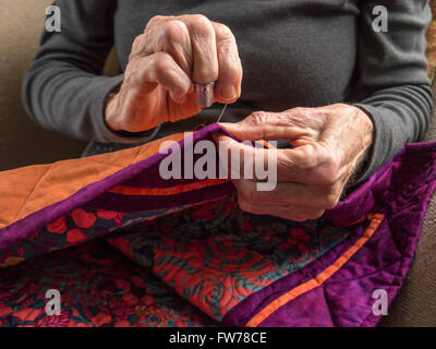 Close up photographie couleur de la mains d'une femme de la haute couture la liaison sur un patchwork coloré. Banque D'Images