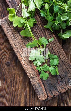 De la coriandre fraîche sur planche à découper en bois, overhead view Banque D'Images