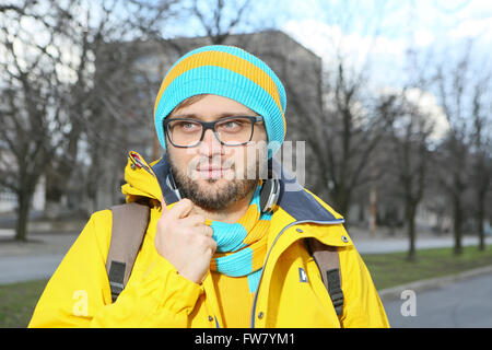 Portrait d'un jeune homme avec des lunettes dans une veste jaune Banque D'Images