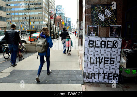 Toronto, Canada. 1 avril, 2016. Les piétons passent comme Black vit Question manifestants continuent d'occuper la cour à l'Administration centrale de la Police de Toronto sur la rue College, à Toronto. Credit : EXImages/Alamy Live News Banque D'Images
