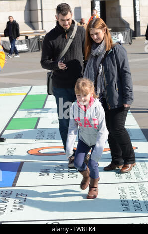 Grand conseil de monopole mis en place à Trafalgar Square dans le cadre du Festival des Jeux de Londres. La fonction jouer de la carte en utilisant un téléphone mobile app. Personnes jouant Banque D'Images