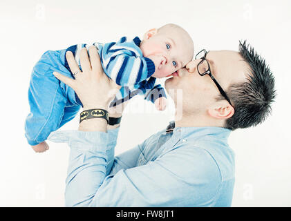 Young man holding et d'embrasser son petit-fils Banque D'Images