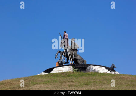 Un homme et une femme le nettoyage de la statue de Bhai Fateh Singh au Baba Banda Singh Bahadur Memorial Gardens au Pendjab, en Inde. Banque D'Images