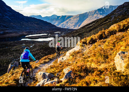 Les vététistes sur la descente de Bealach na pou du poisson en Ecosse Highland Torridon Beinn Alligin avec Liathach et à distance Banque D'Images