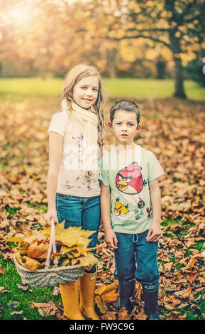 Deux enfants debout dans autumn park Banque D'Images