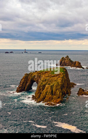 Les Knght Enys Dodman et piles de mer à Land's End avec phare au-delà de Drakkars, Cornwall, England, UK Banque D'Images